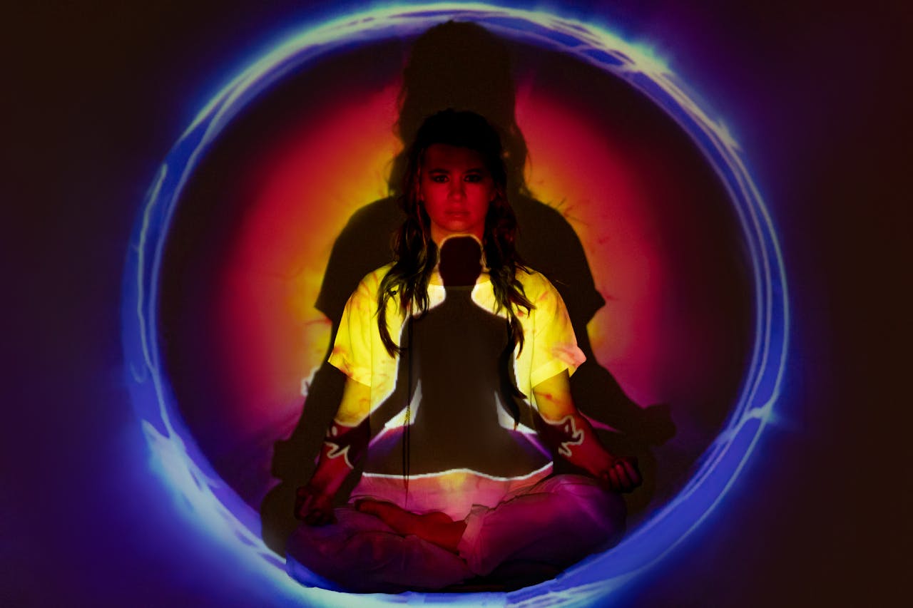 Woman meditating with vibrant aura and energy field.